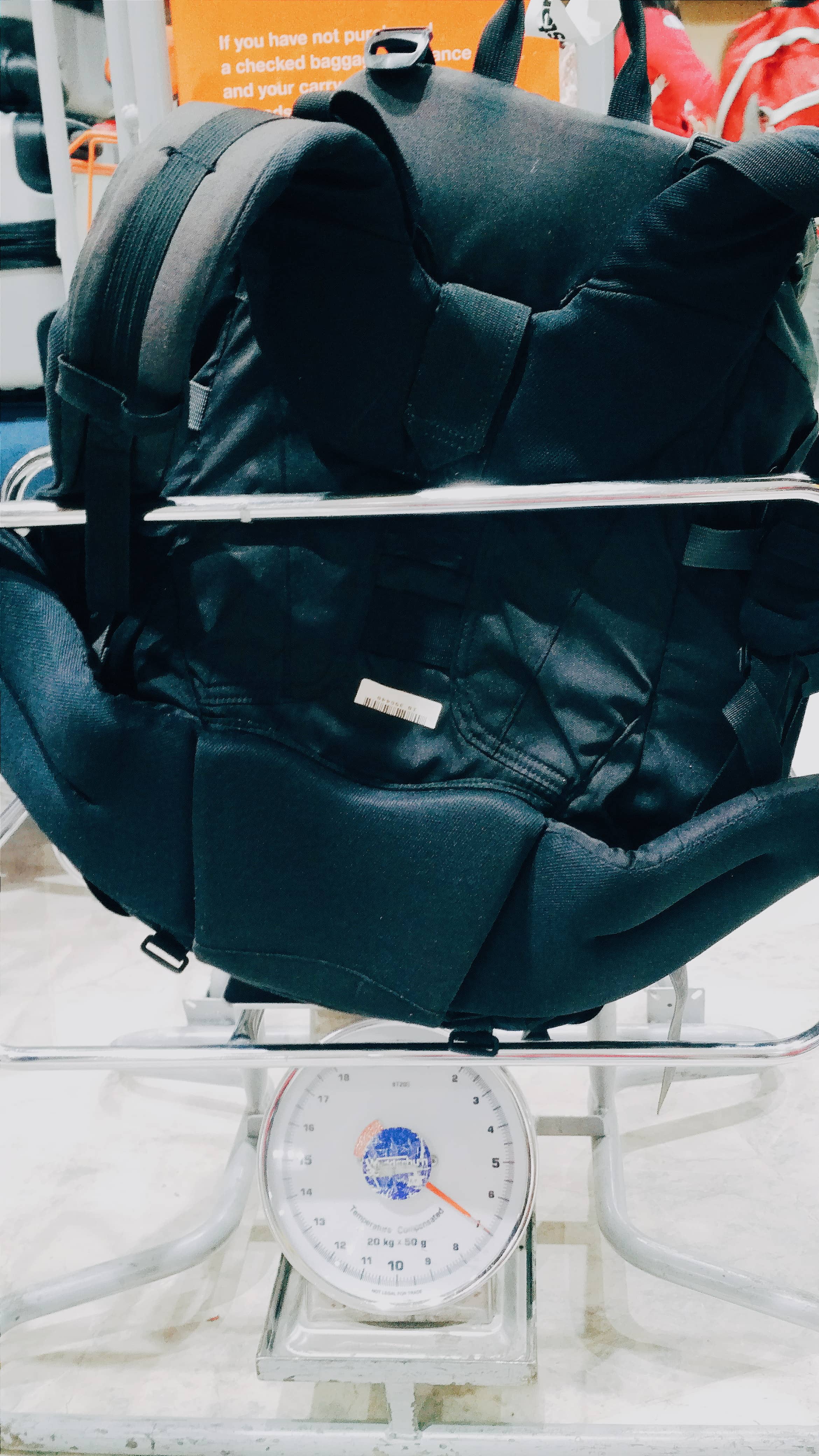 Tips To Avoid Paying For Hand Luggage, Weighing a traveling backpack in the airport.