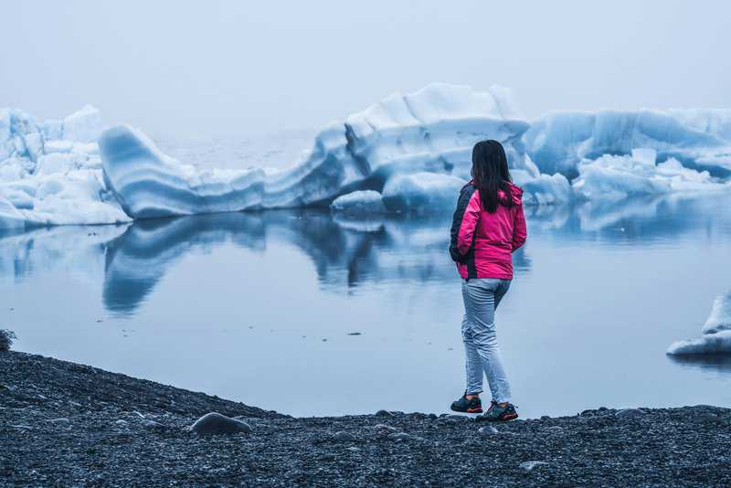 10 Best Destinations for Solo Travel Right Now, Woman in Jökulsárlón Lagoon Iceland - Iceland Glaciers Tour - 9 Day Iceland Itinerary with Kids